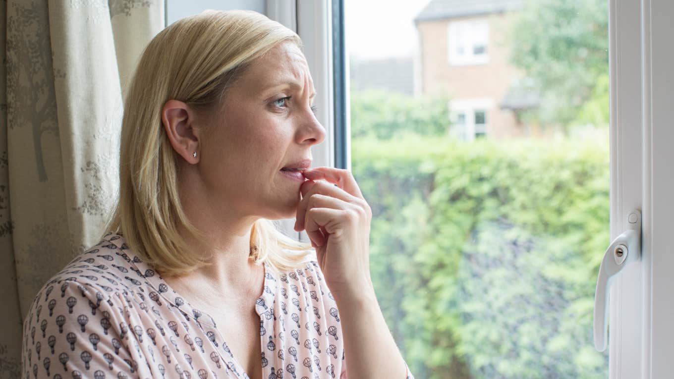 Concerned woman looking out the window