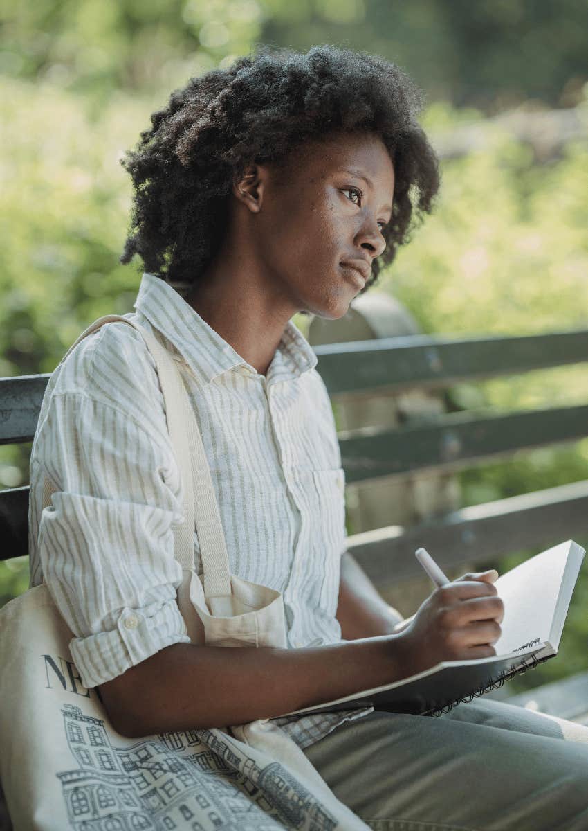 woman sitting outdoors and journaling