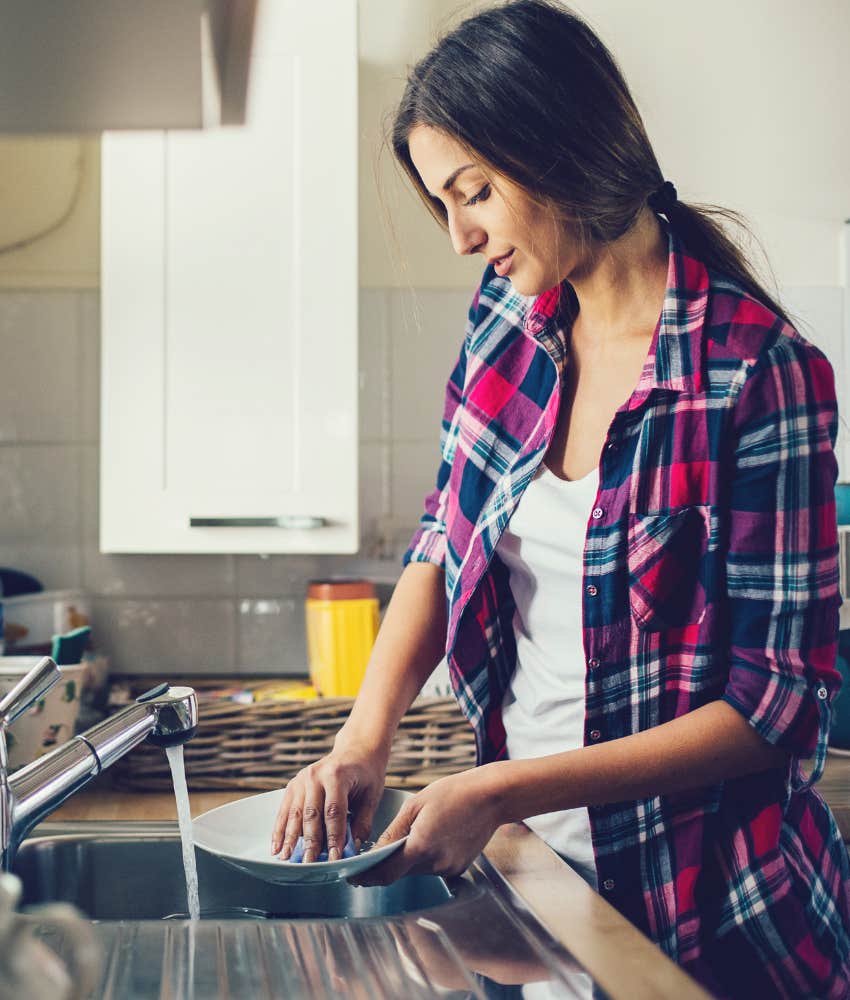 woman washing dishes at kitchen sink