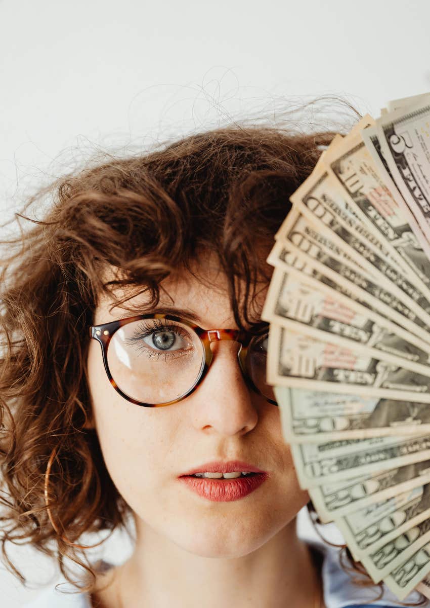 woman with abundance mindset holding money quantum leaping income