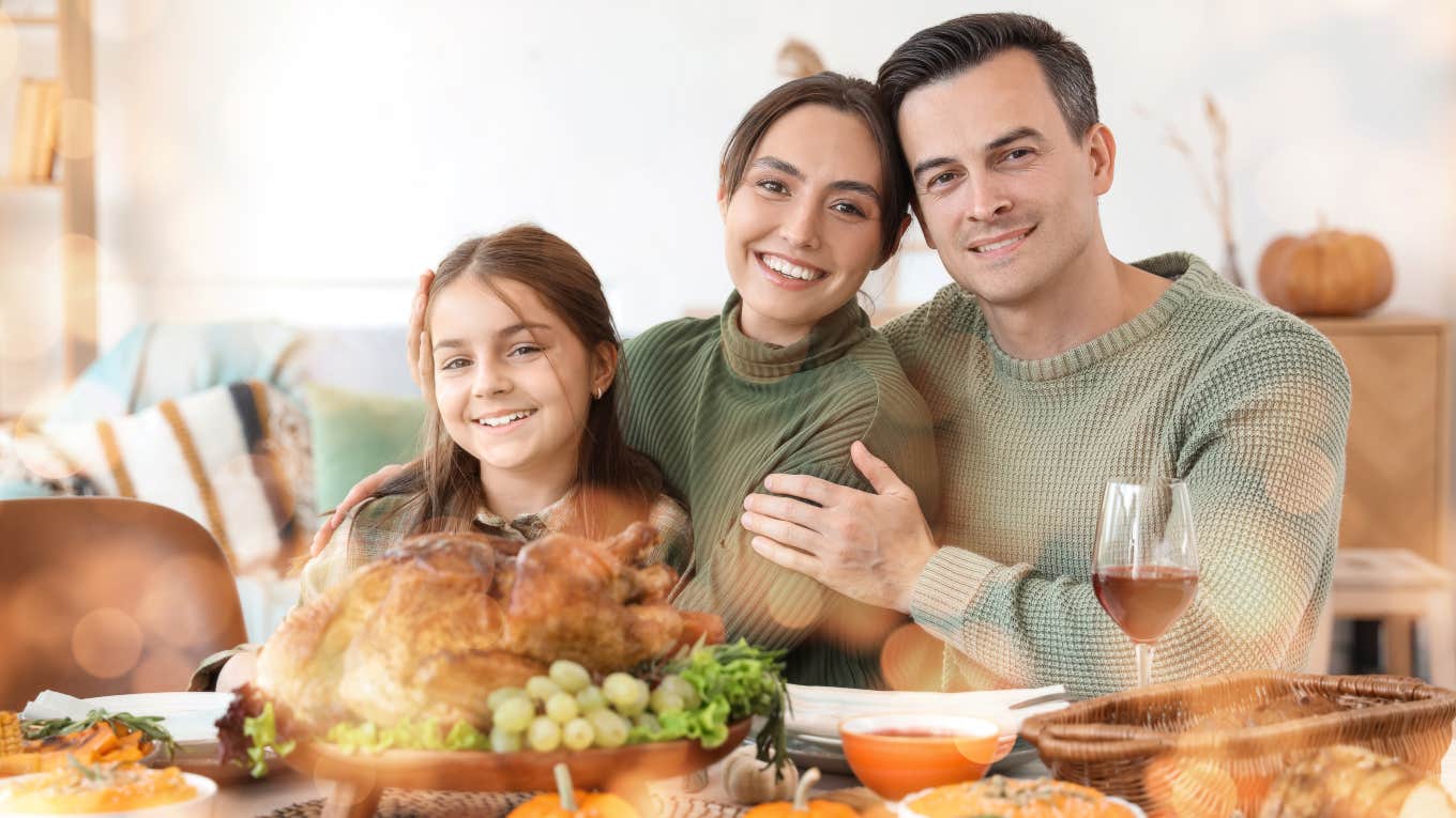 parents and daughter sitting at Thanksgiving table