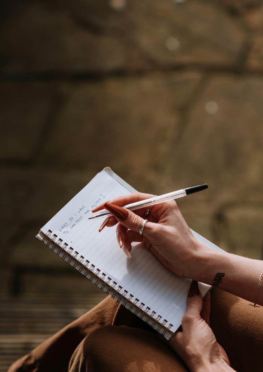 woman writing a list in a notebook