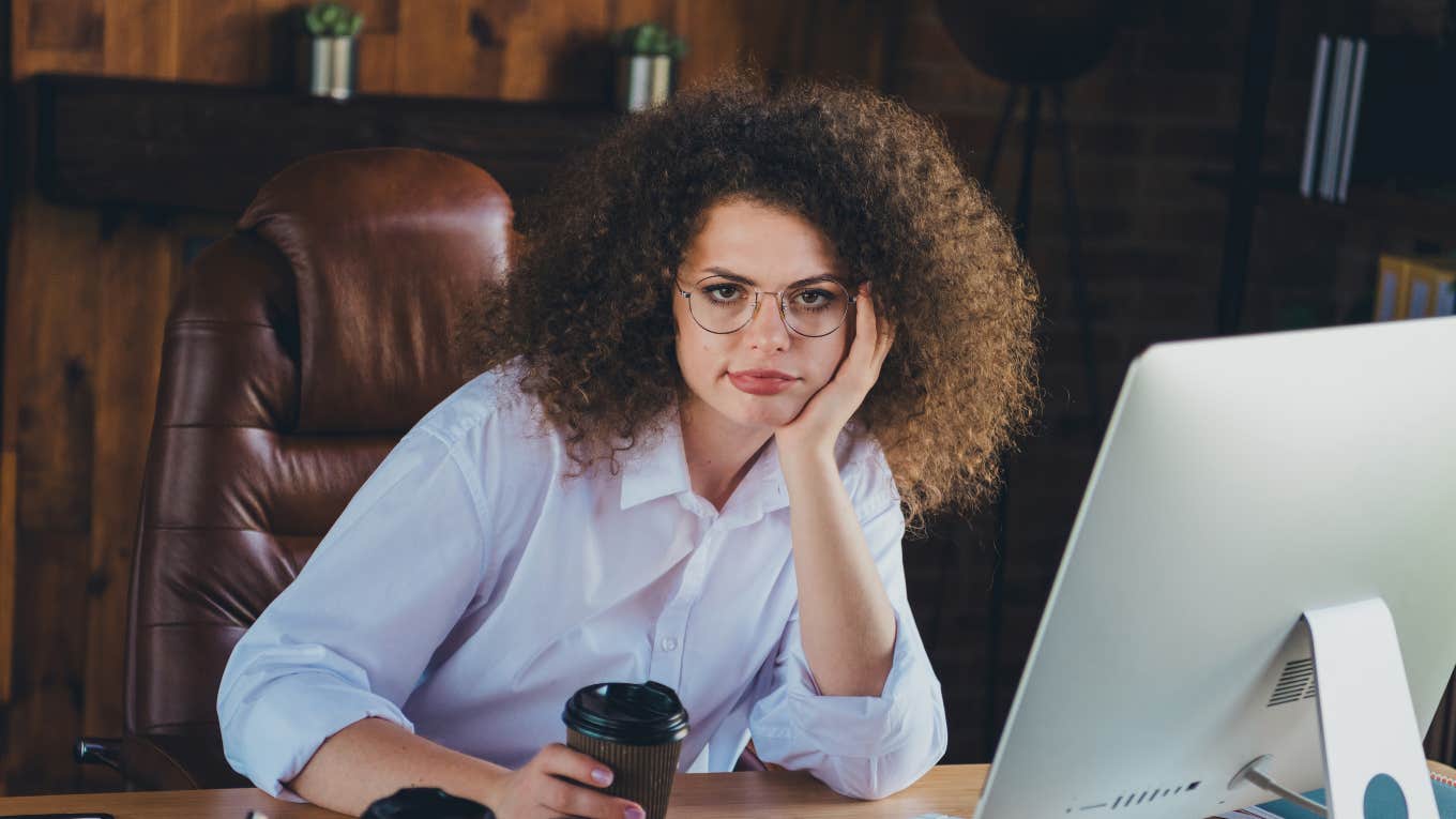 Employee sitting at desk with a cup of coffee