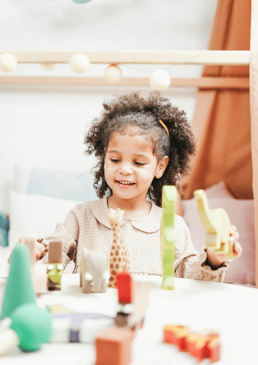 young girl playing with her toys alone