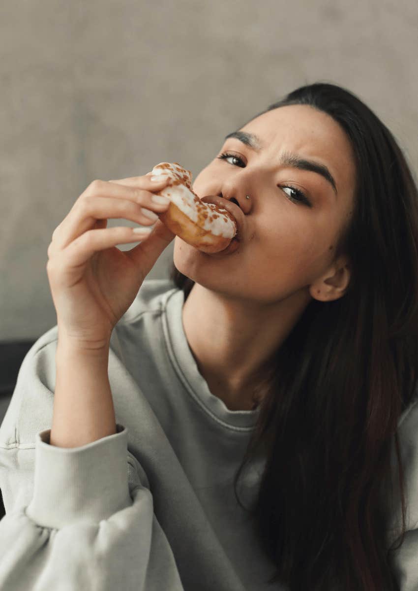 young woman biting into a donut