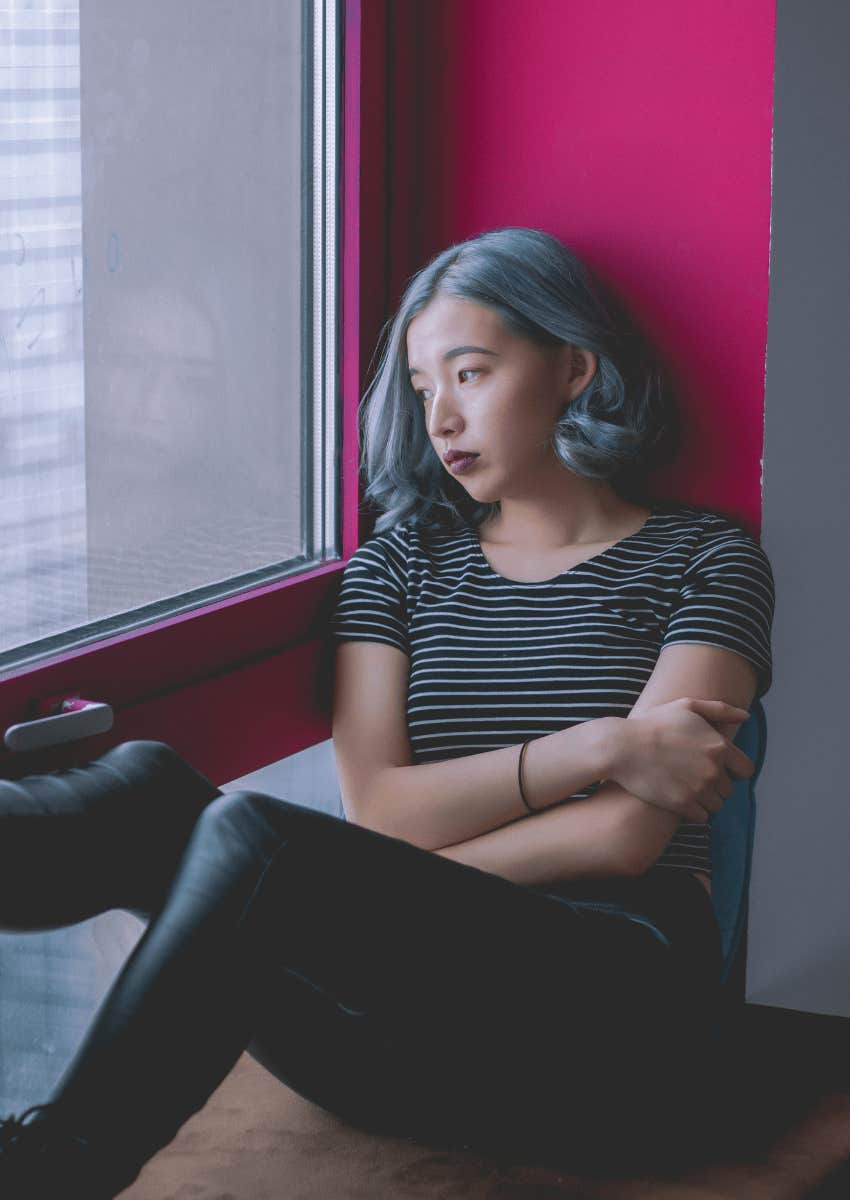 young woman looking out of window