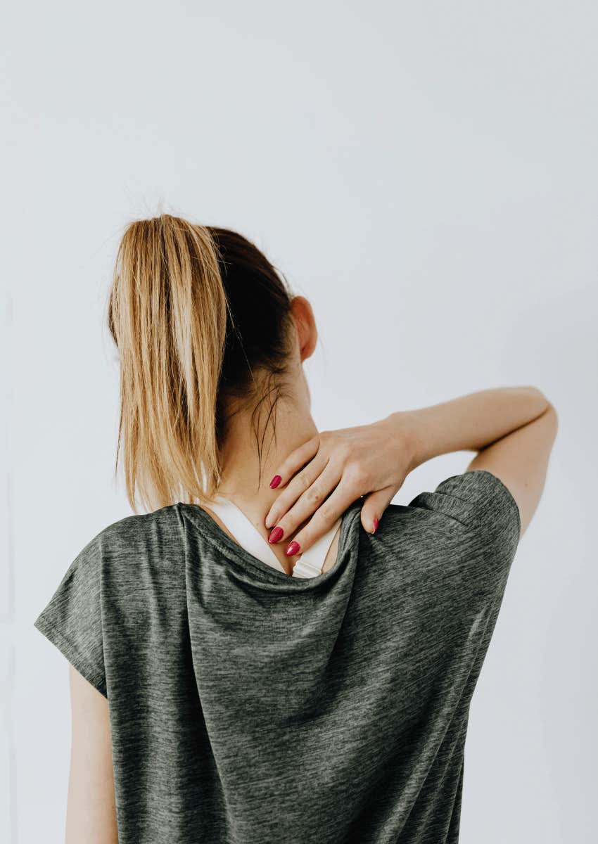 young woman rubbing out neck pain