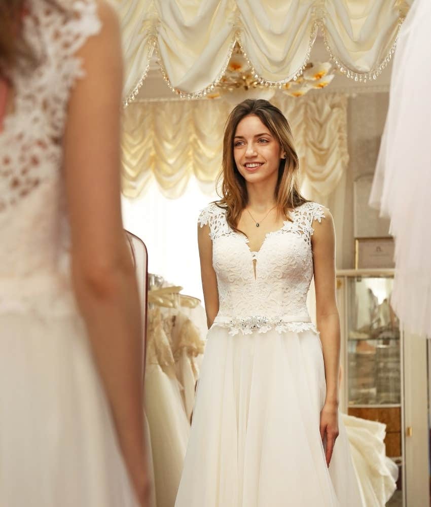 young woman trying on her mom's wedding dress