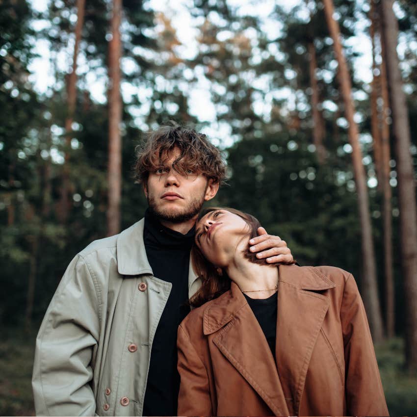 couple in love in the forest at sunset on a date hugging in a coat in the summer.