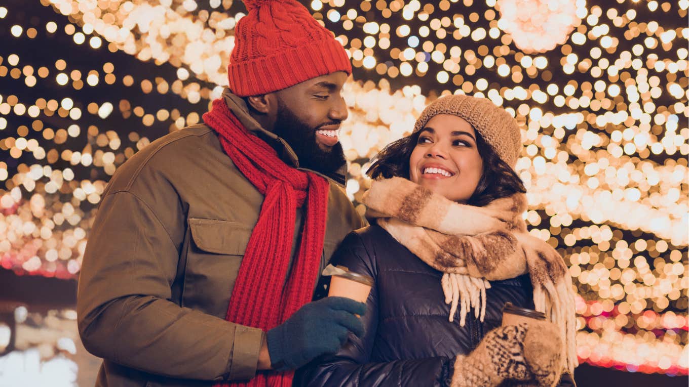 Couple enjoying drama-free winter holidays in front of lights