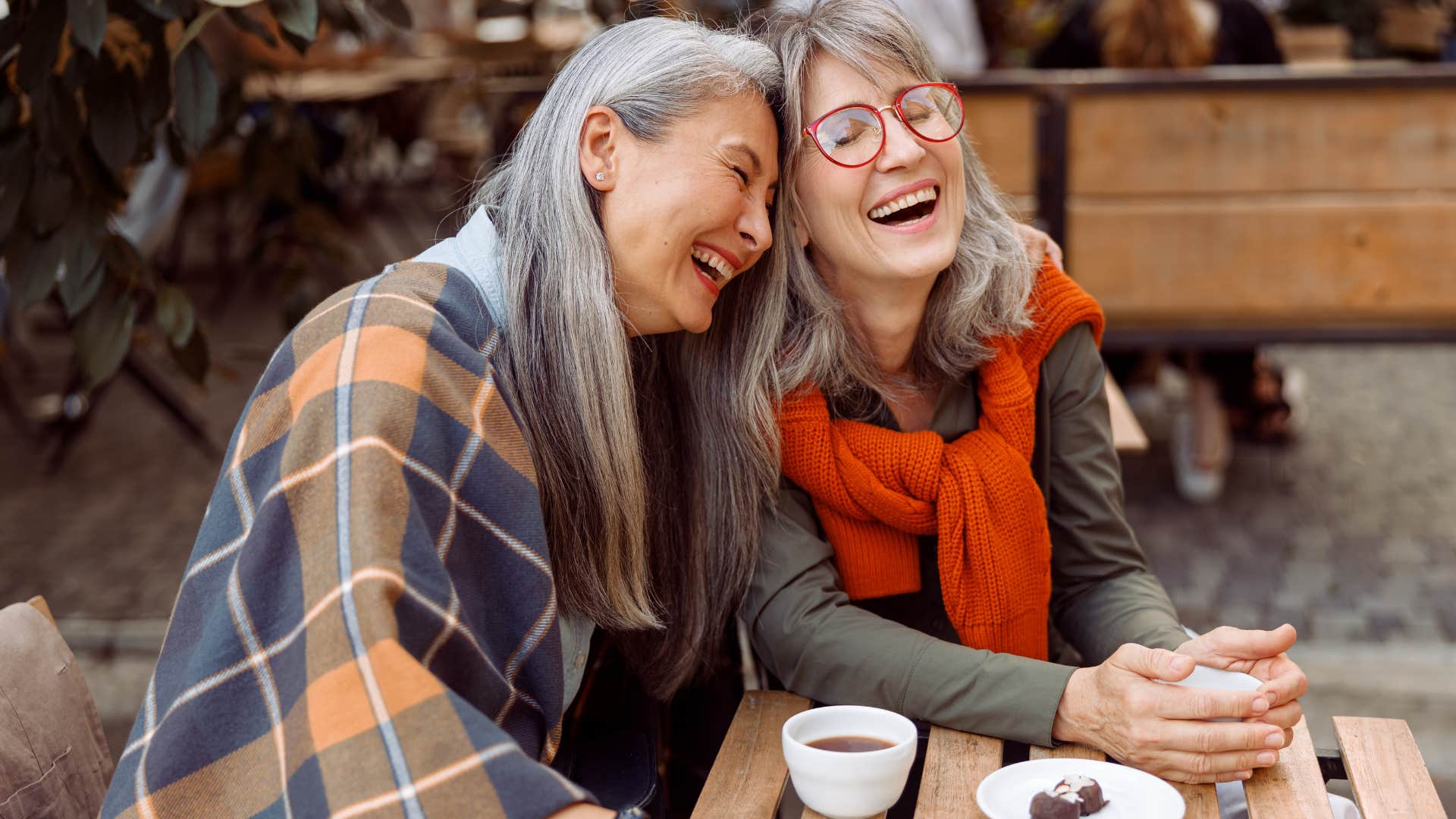 Two older women smiling and hugging each other