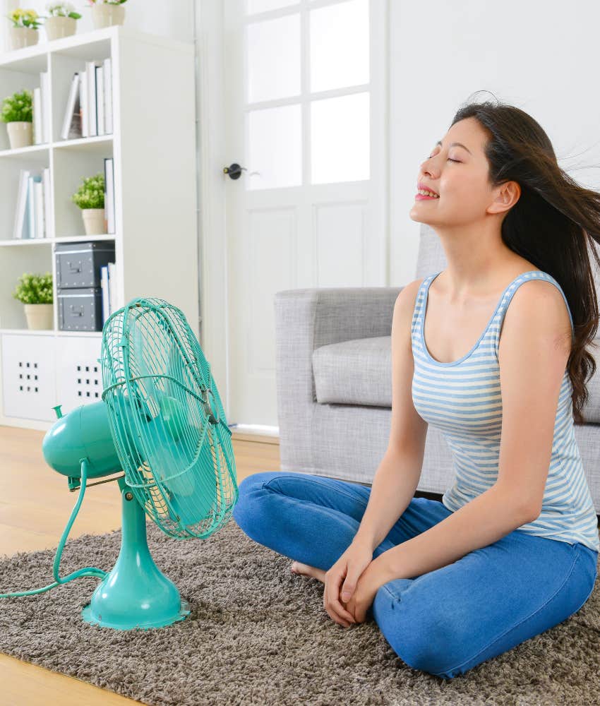 Woman sitting in front of fan