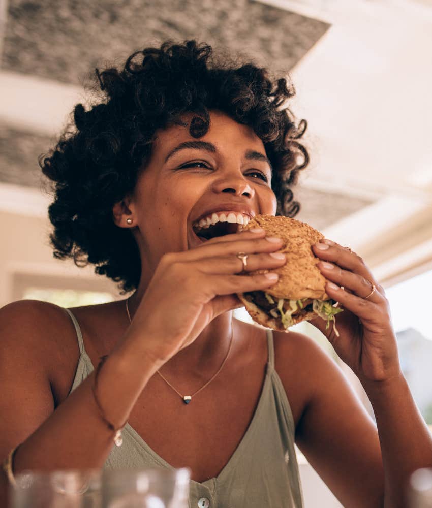 woman eating a burger with her hands