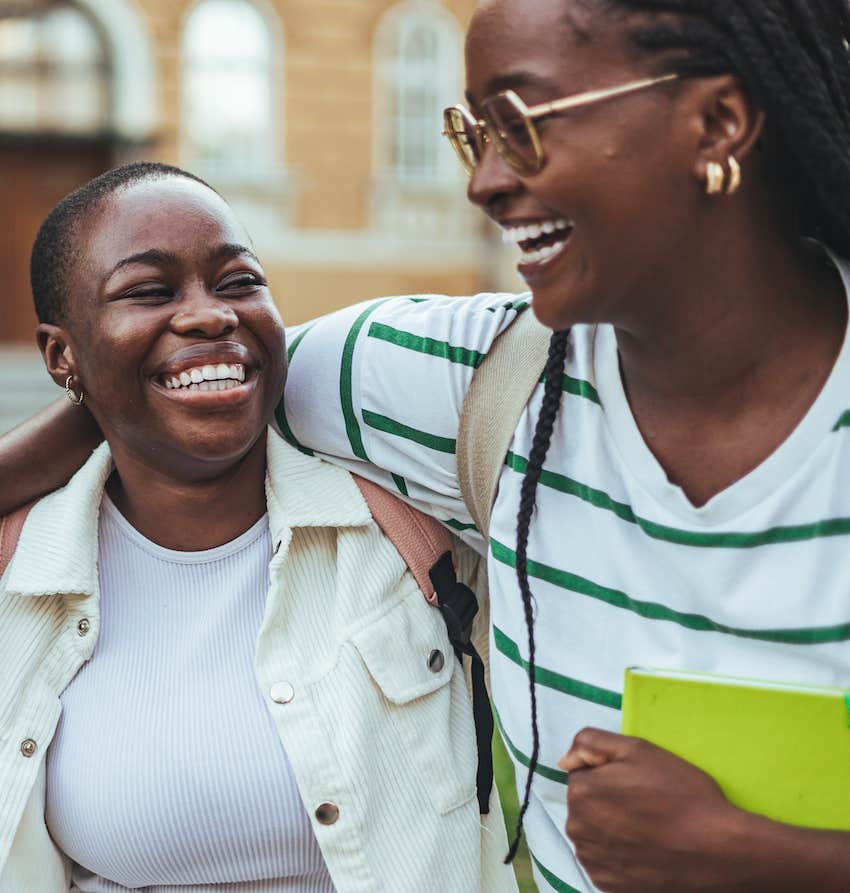 Two friends smile authentically and walk together