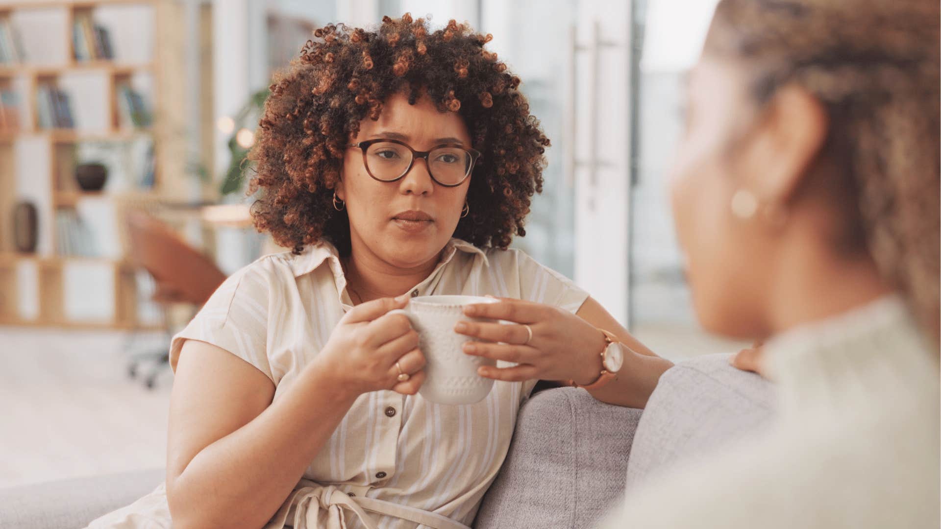 Woman with coffee talks to friend about being OK alone