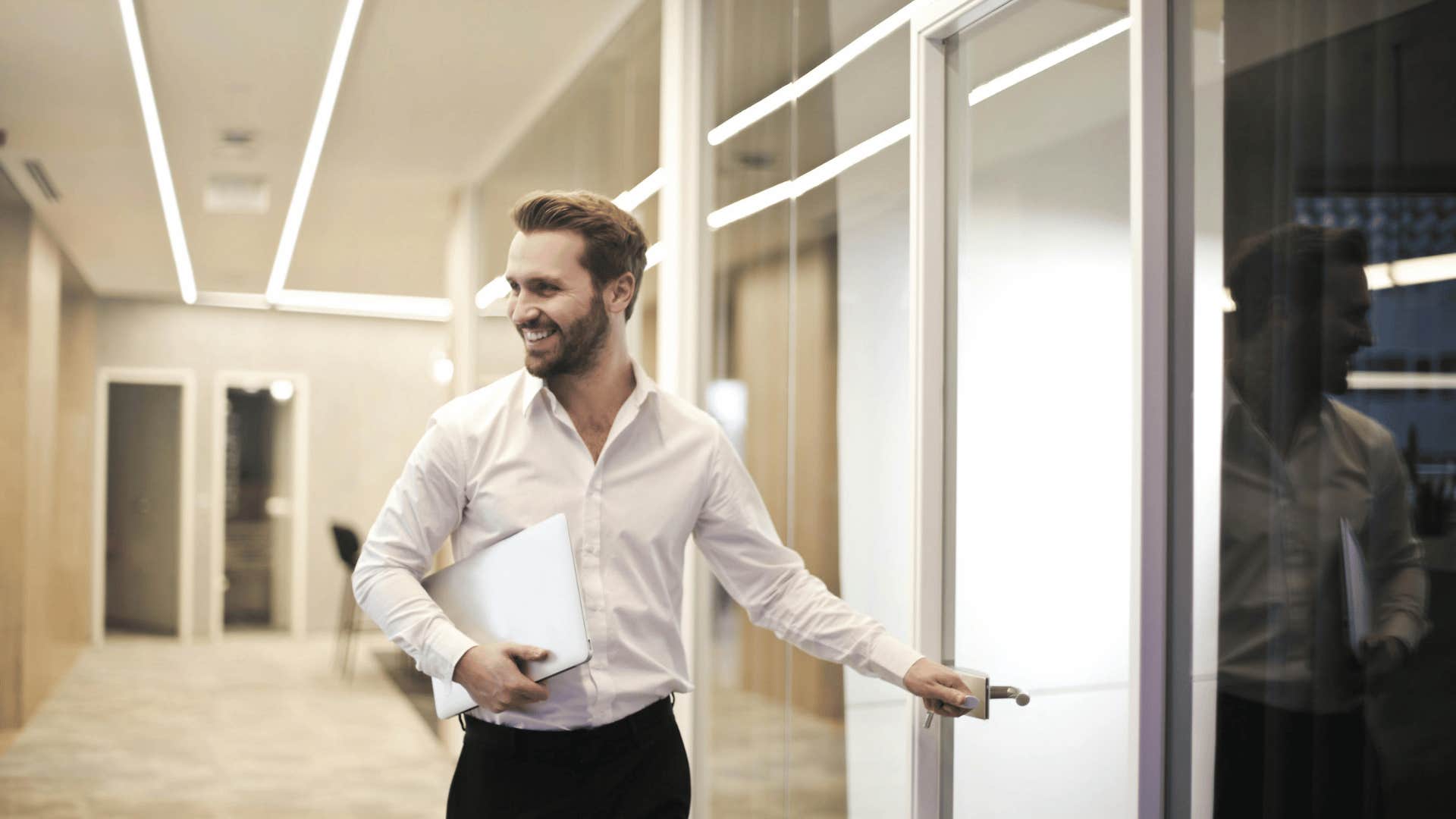 man walking down a hallway smiling