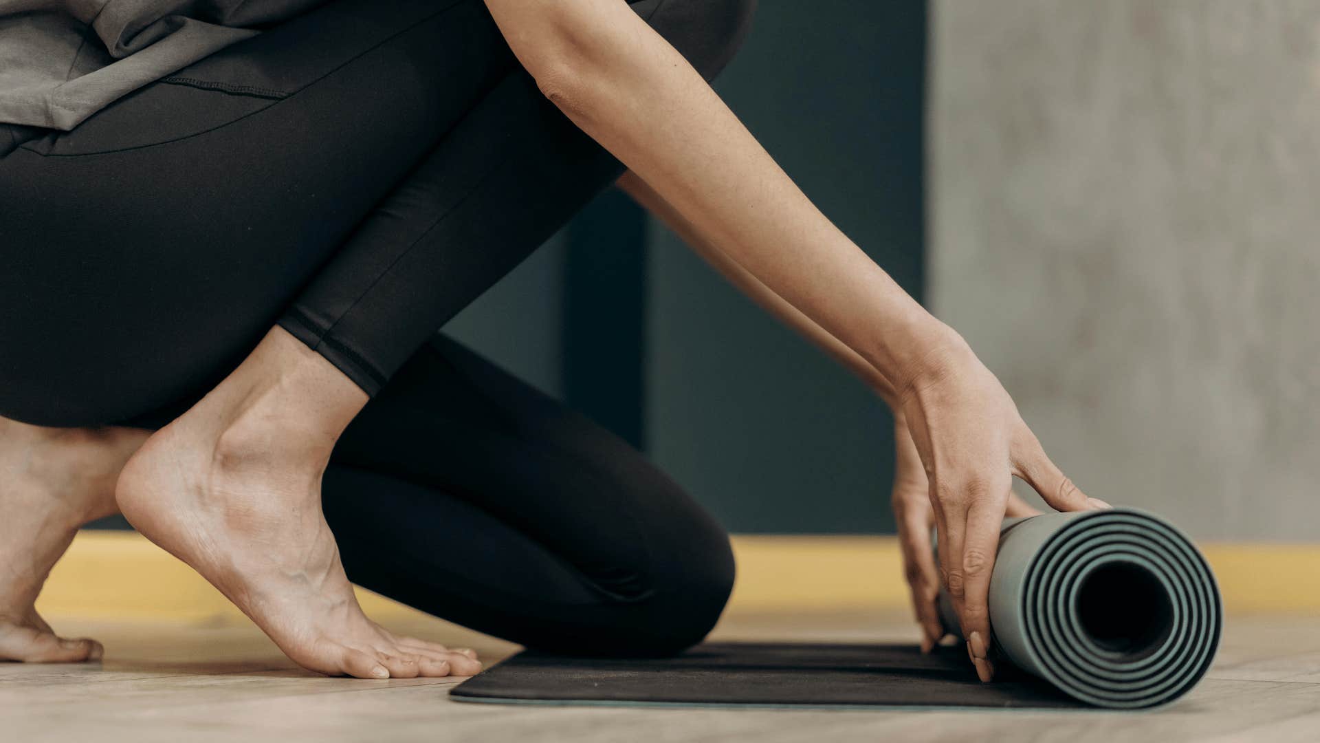 woman rolling up a mat