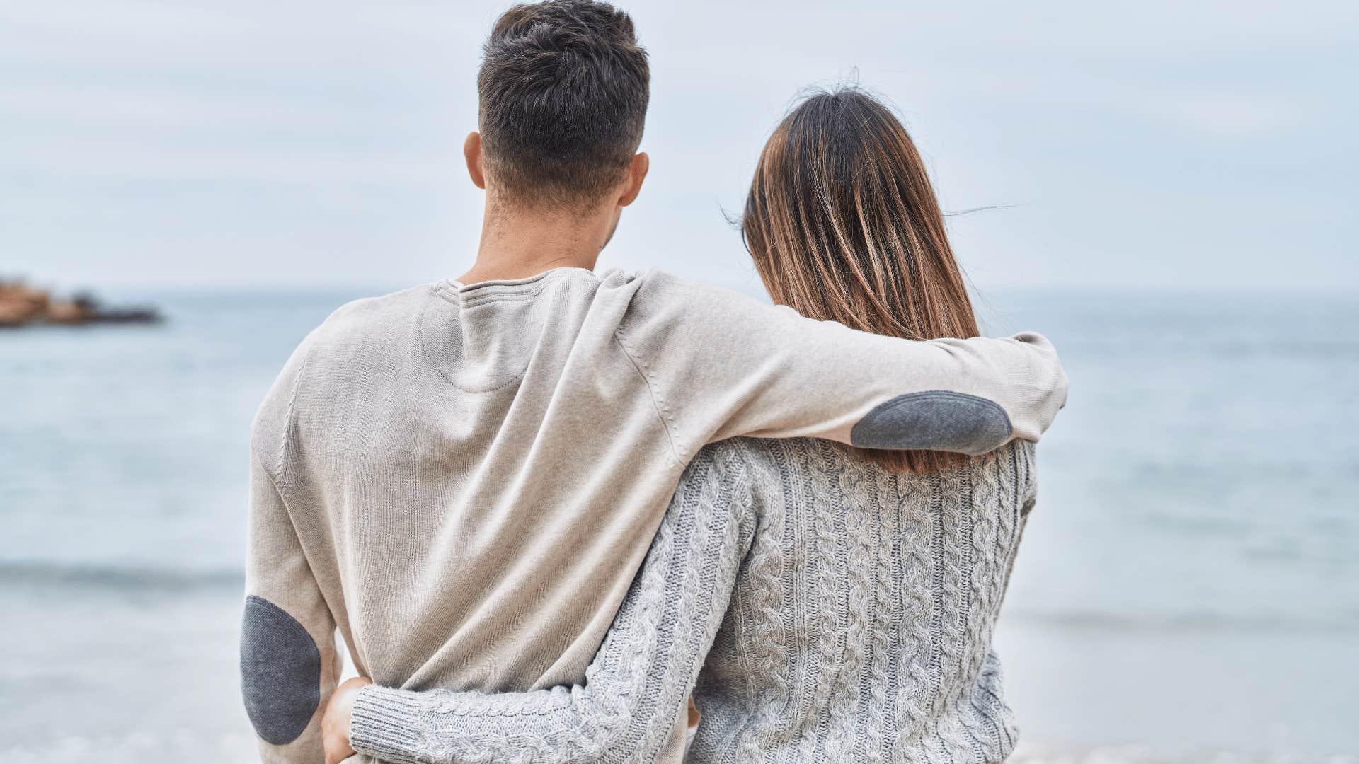 couple hugging looking out at the water