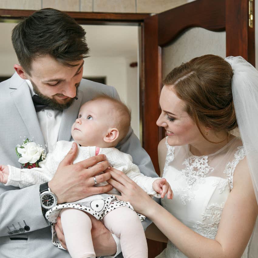 Bride and groom holding their daughter at their wedding