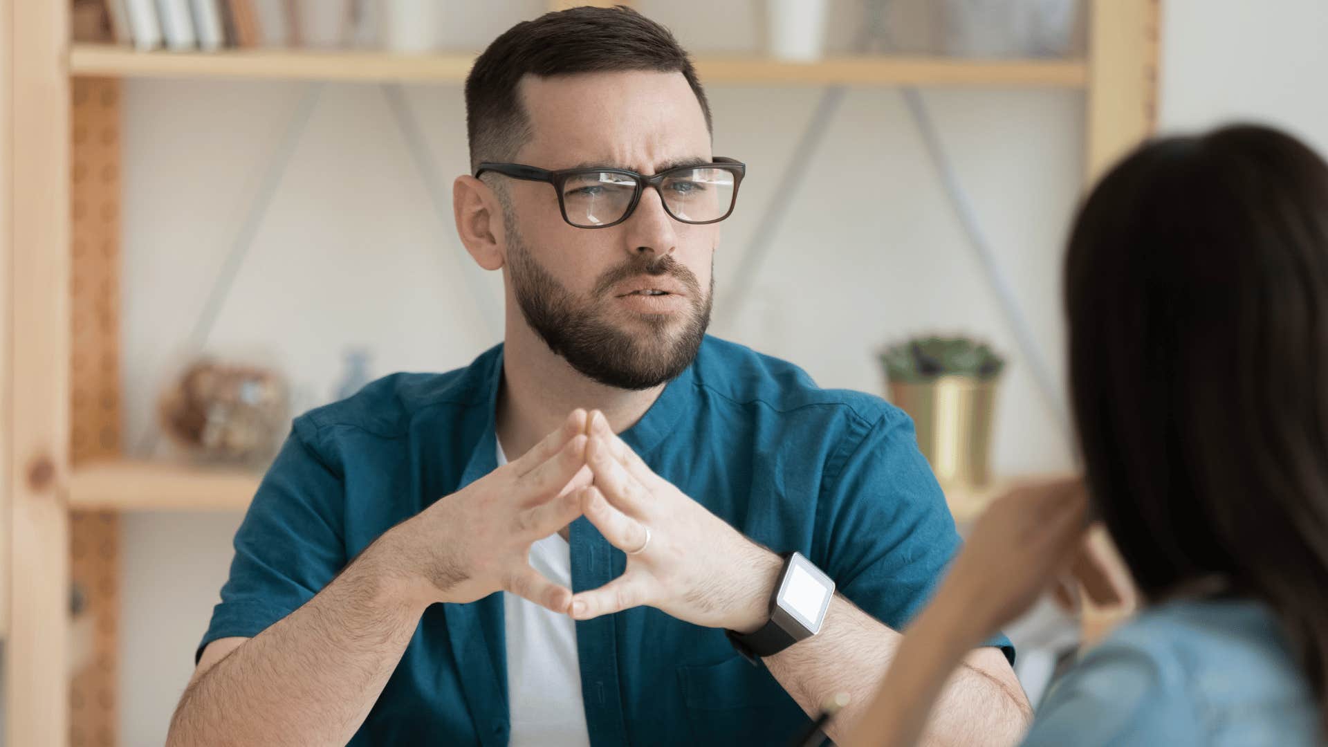 man looking at woman while putting his hands together