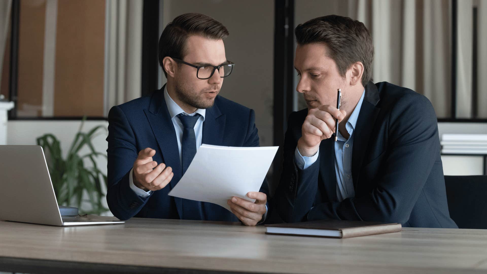 two men looking over document together