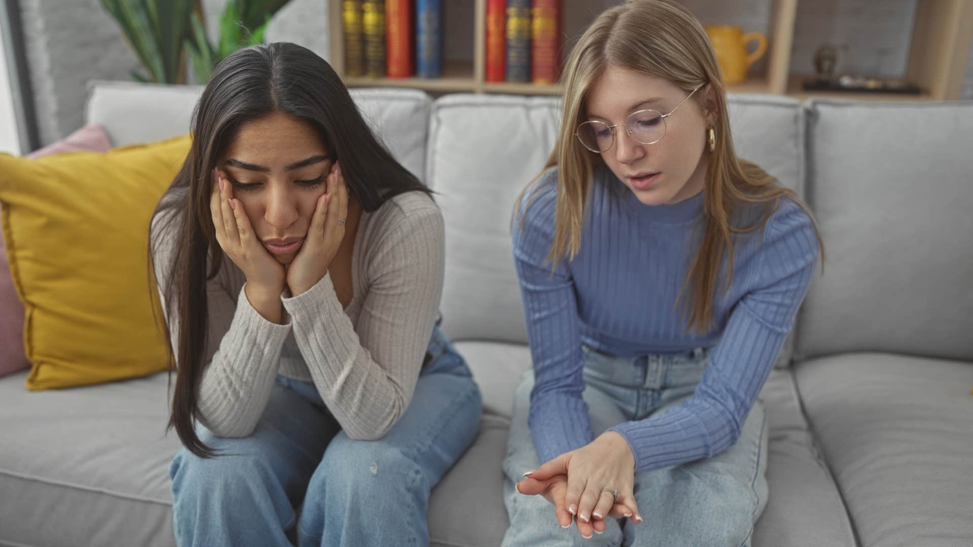 Two friends looking upset and talking to each other.