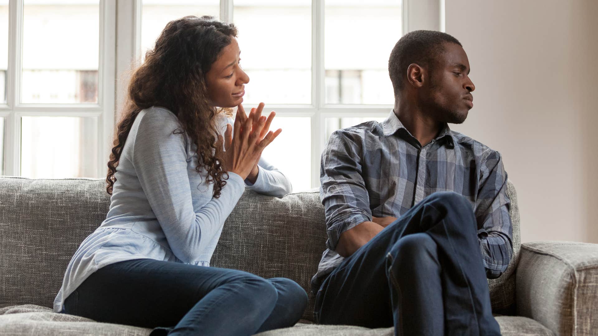 Woman pleading with her upset husband on the couch