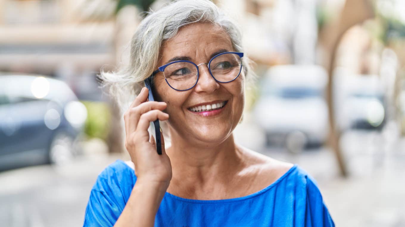 Gen X woman smiling and talking on the phone.