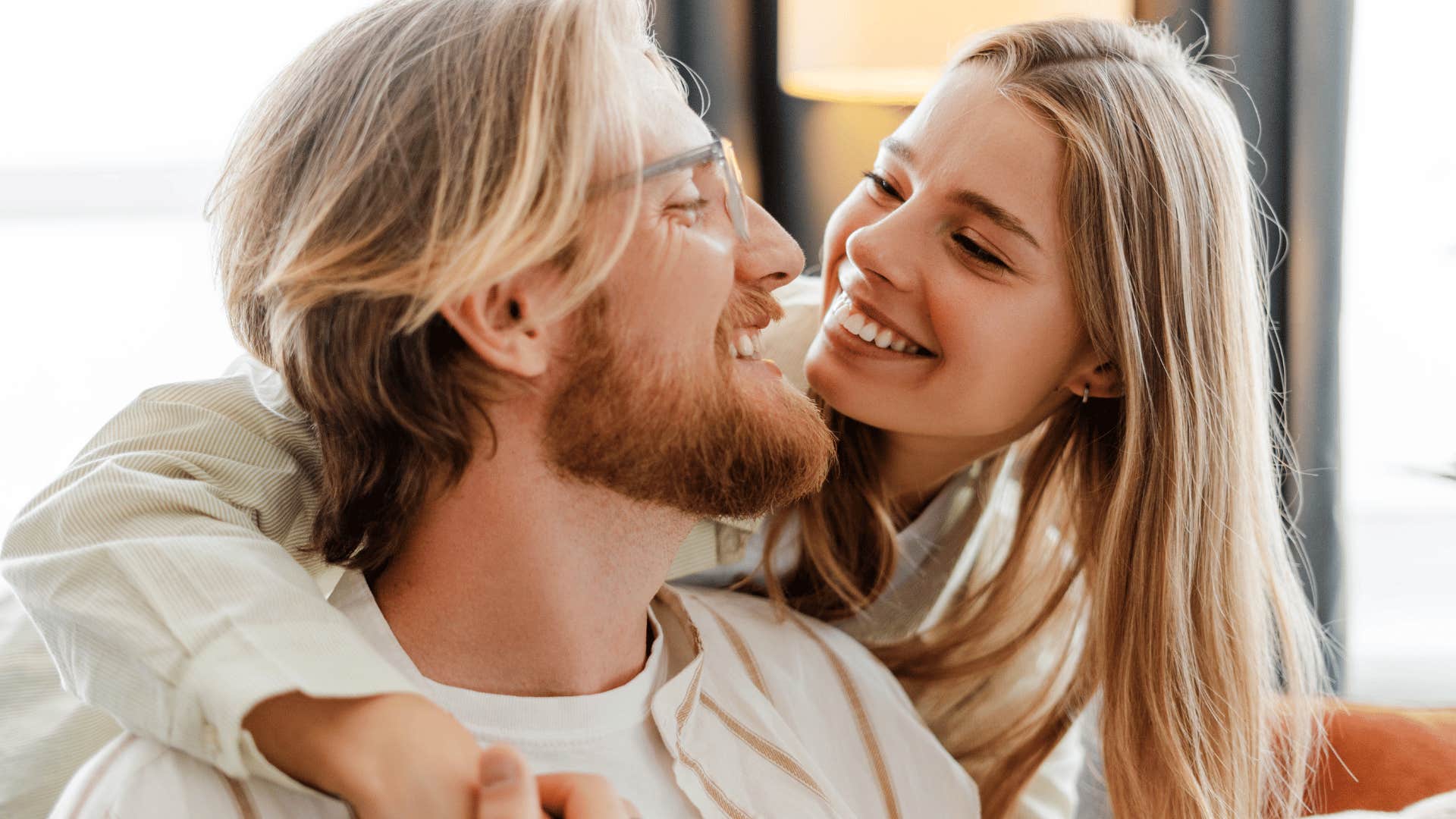 woman hugging man and looking at him