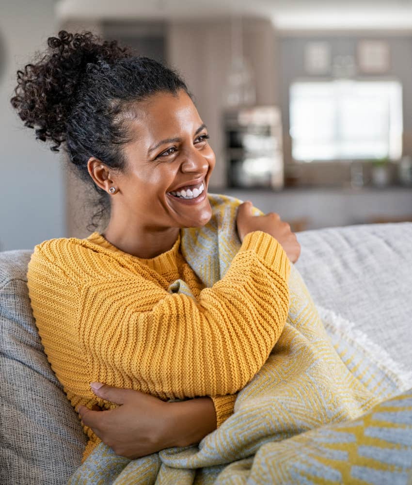 happy woman sitting on a couch smiling