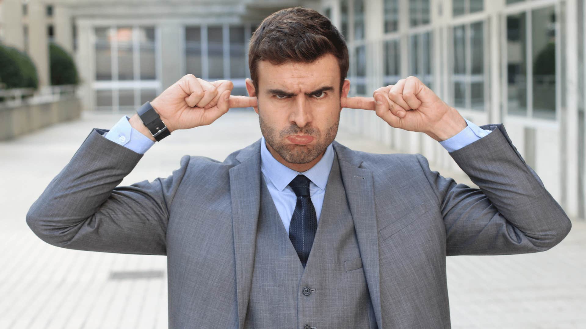 Cold-hearted man puts fingers in his ears to minimize his harmful impact