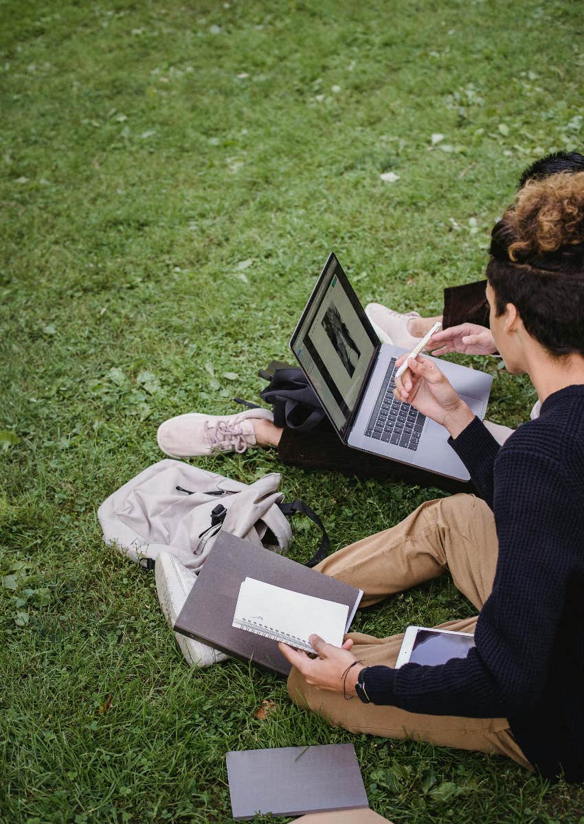 college students sitting outside studying