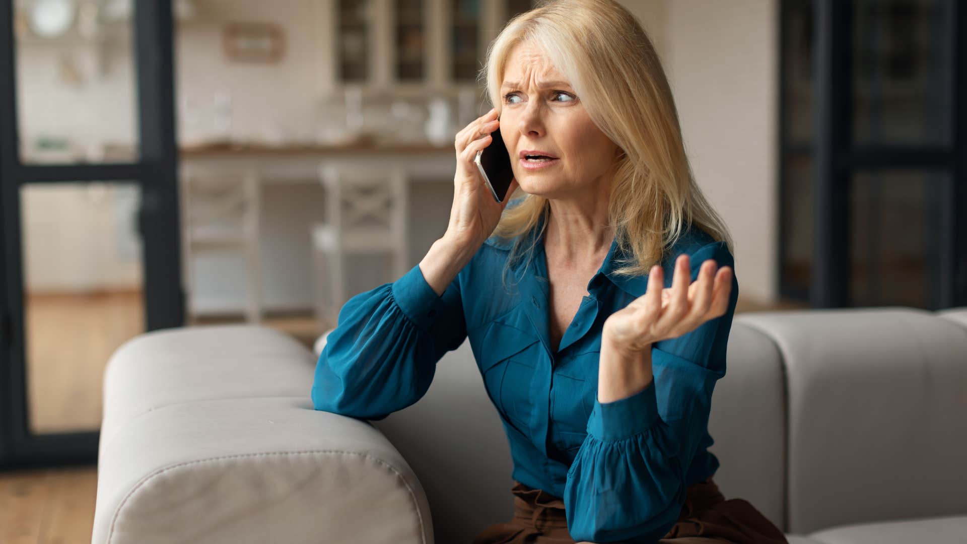 Older woman looking annoyed talking on the phone. 