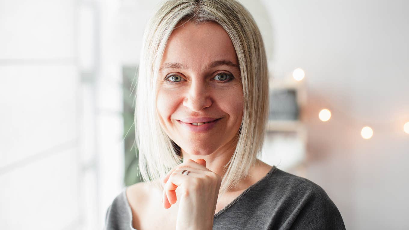 Older blonde woman smiling while looking at the camera.