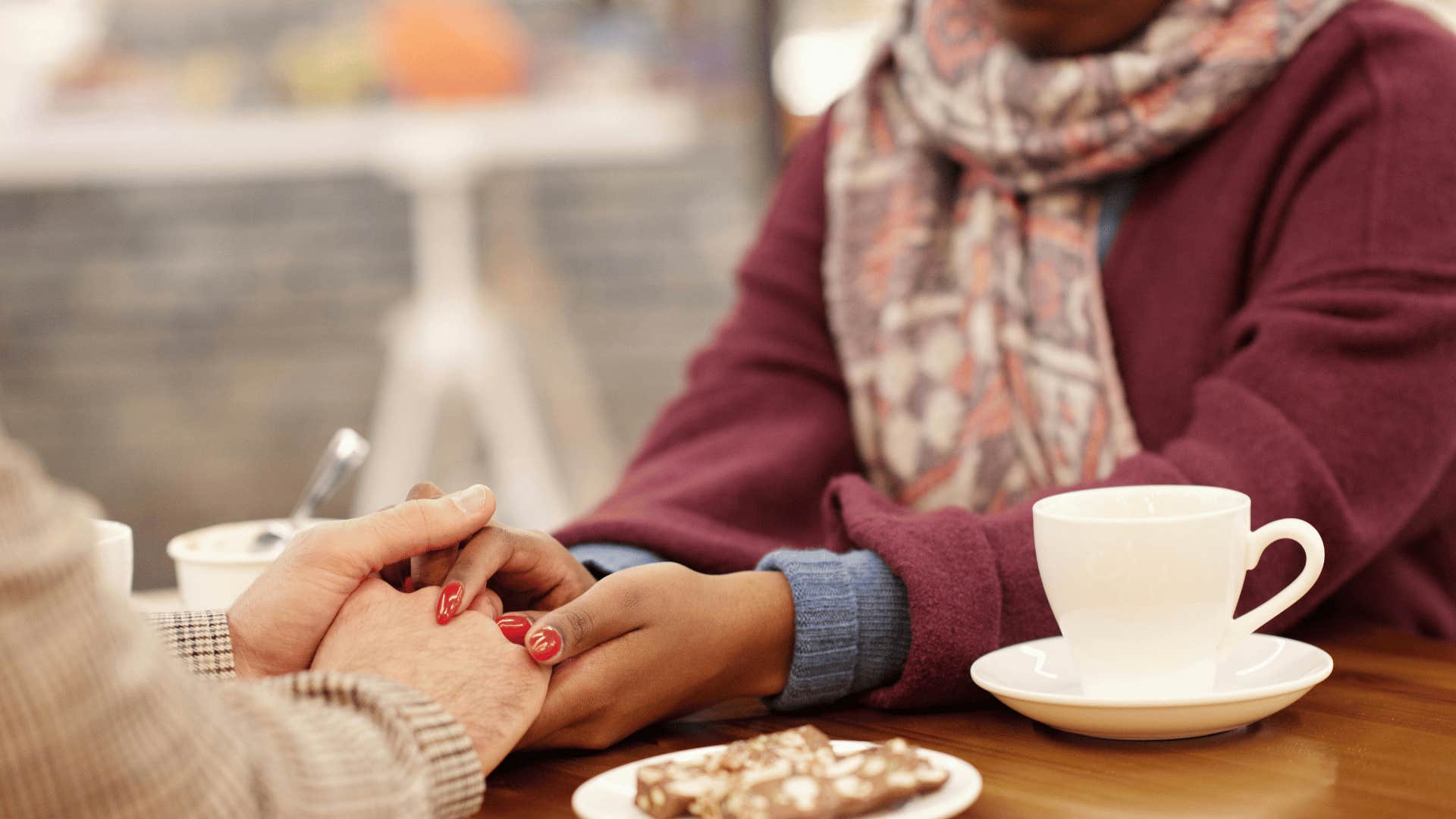 couple holding hands on table