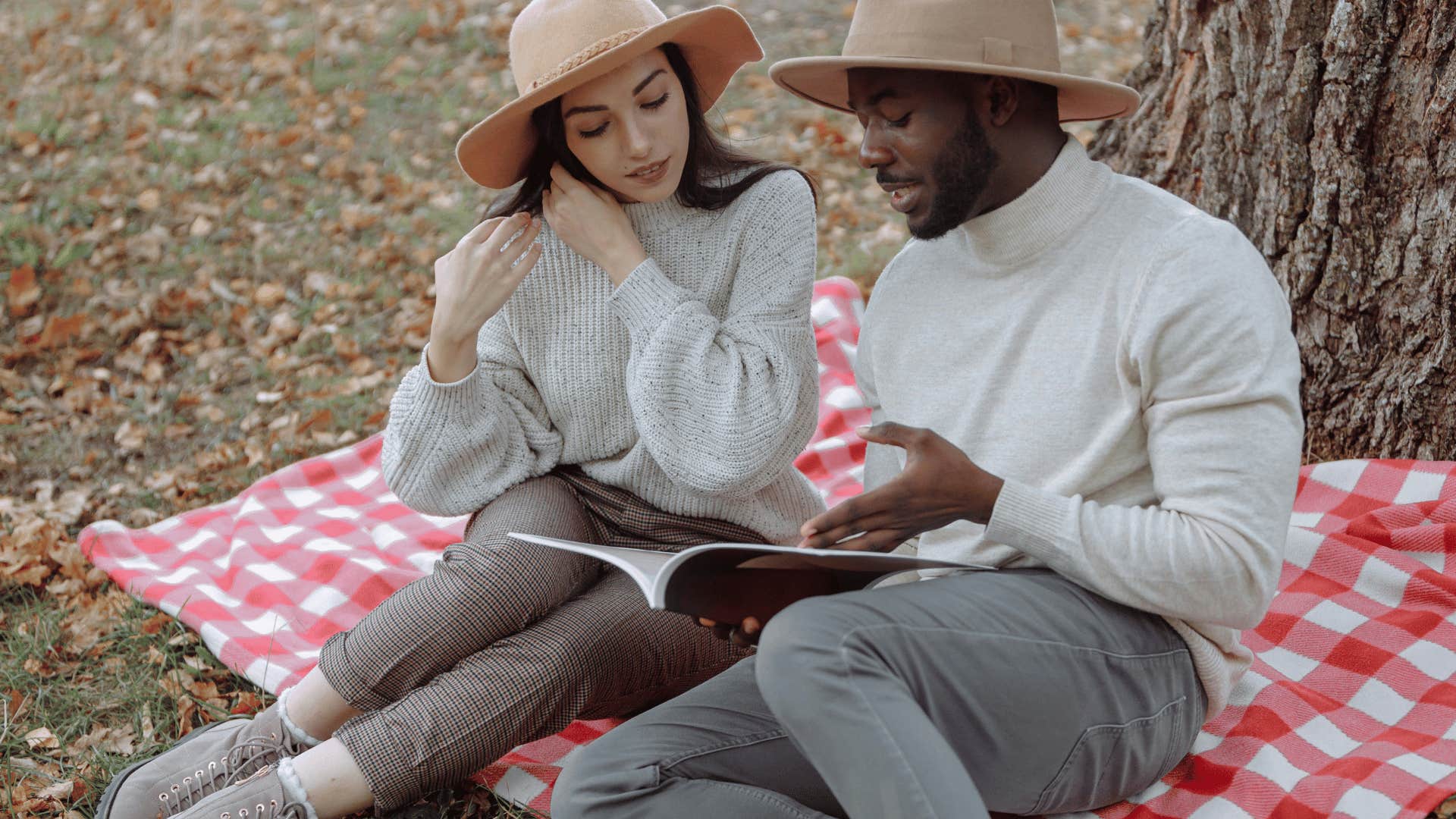 couple sharing a book on a picnic