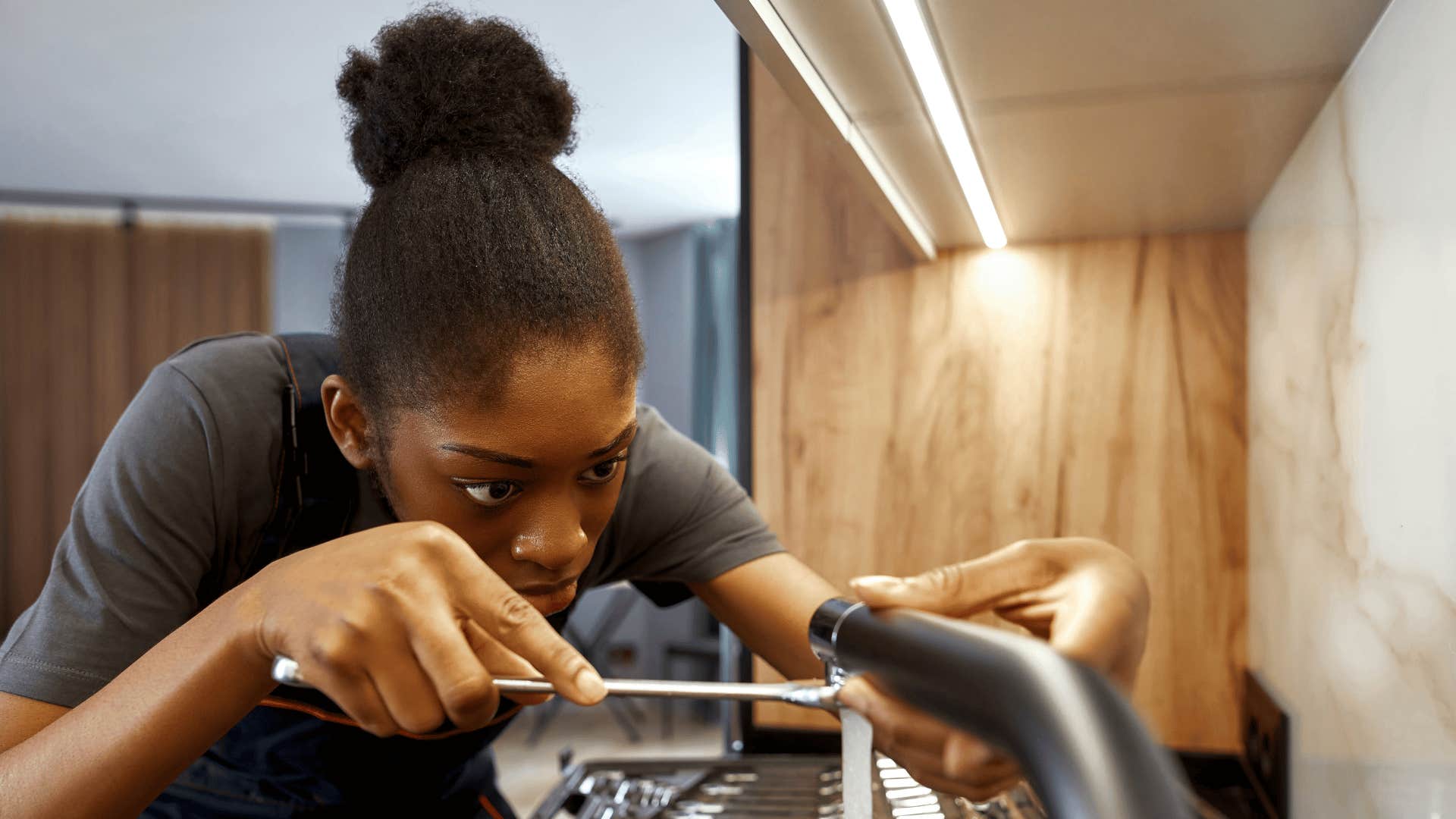 woman fixing a sink