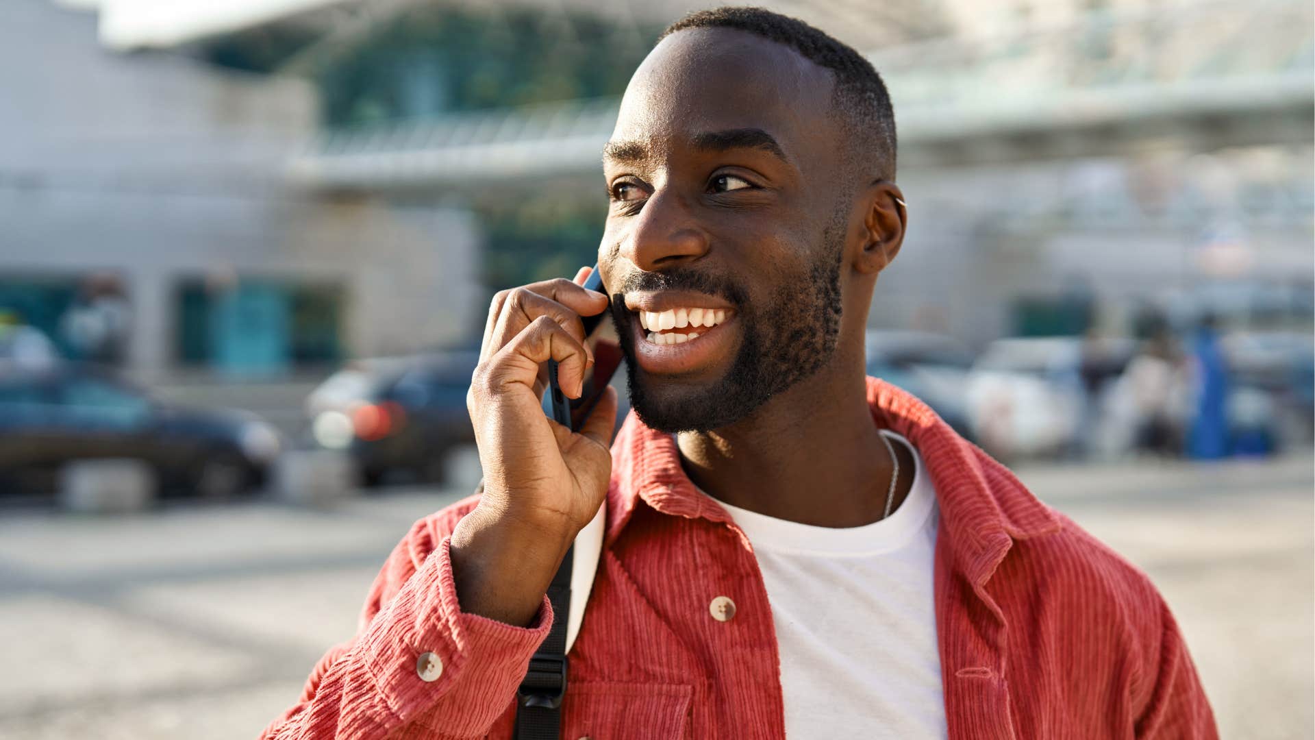 Man smiling and talking on the phone.