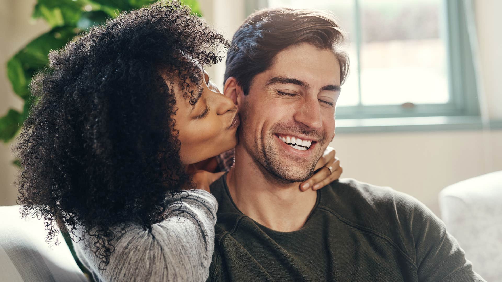 Woman kissing her partner on the cheek.