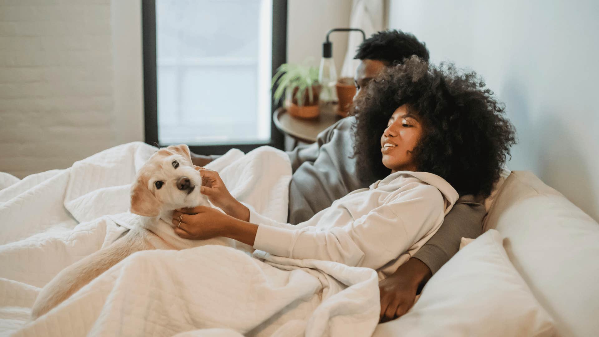 couple in bed with a dog