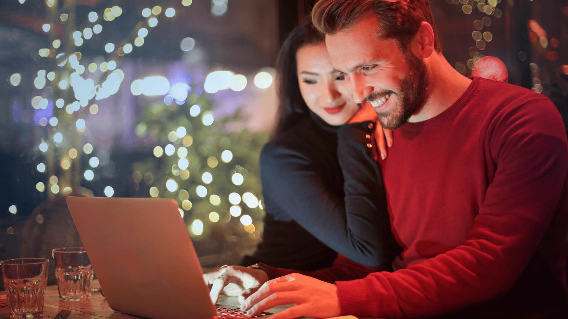 couple smiling in front of a laptop