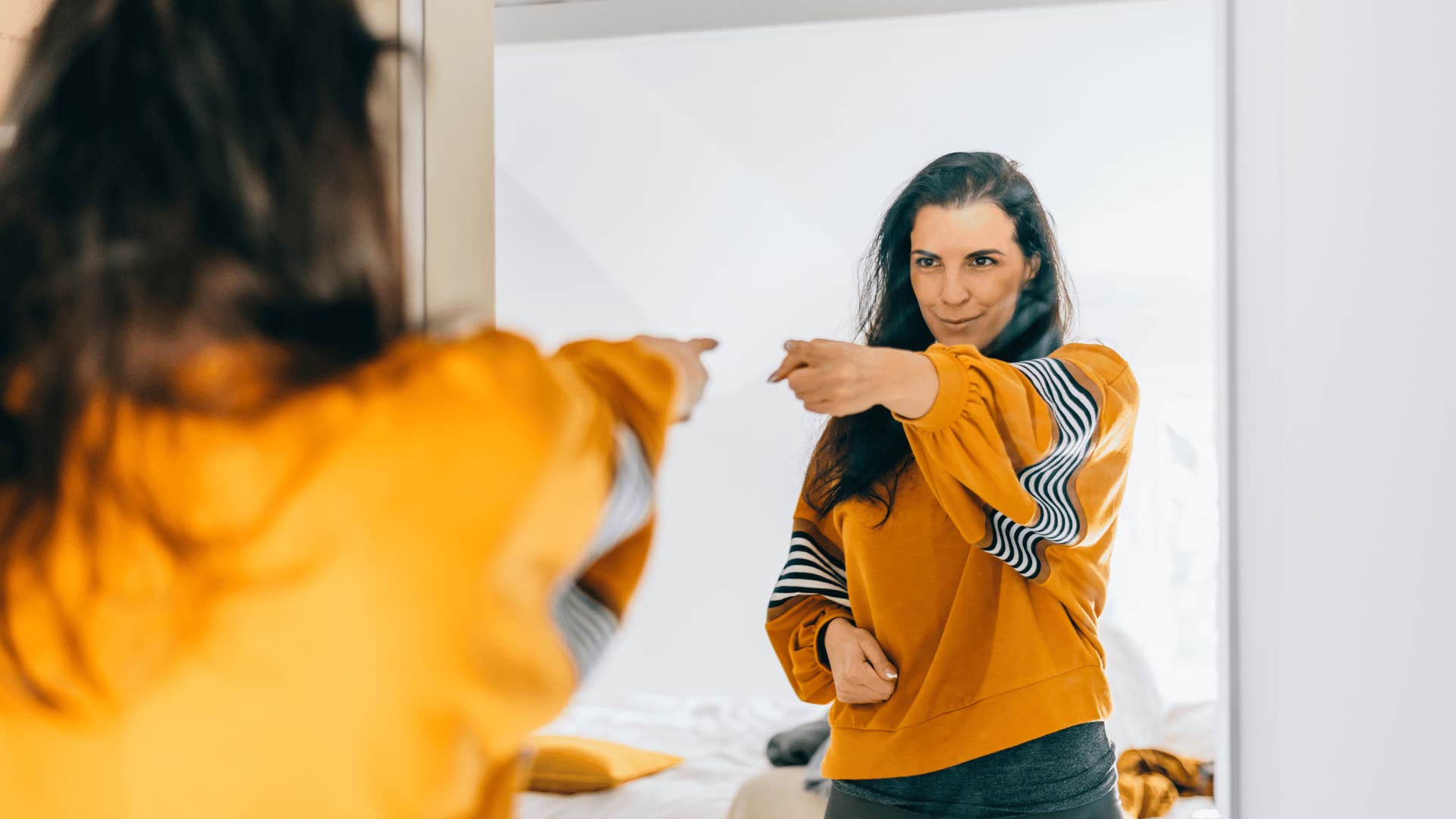 woman pointing at herself in mirrors