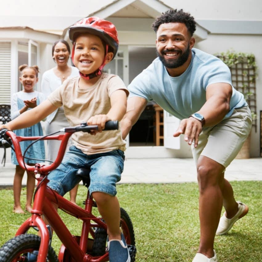 dad teaching son how to ride bike