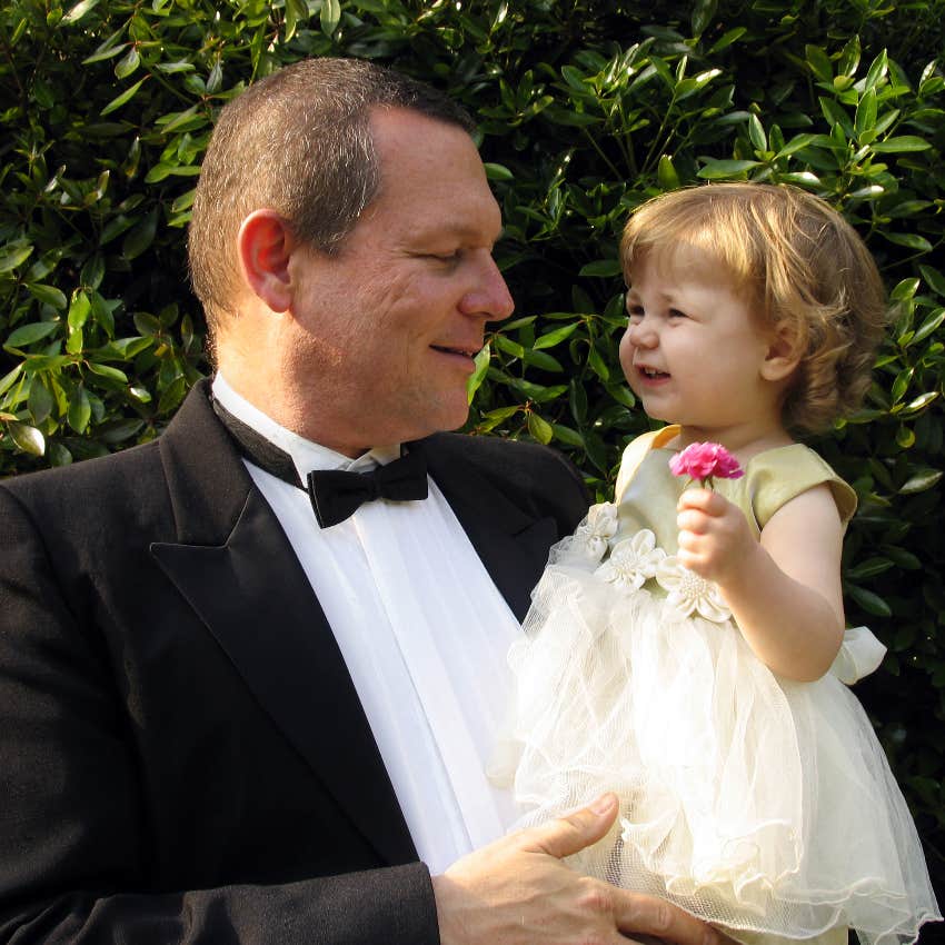 Dad holding his toddler at a wedding