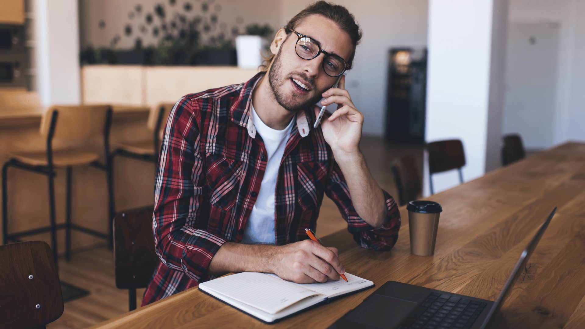 man on the phone and writing 