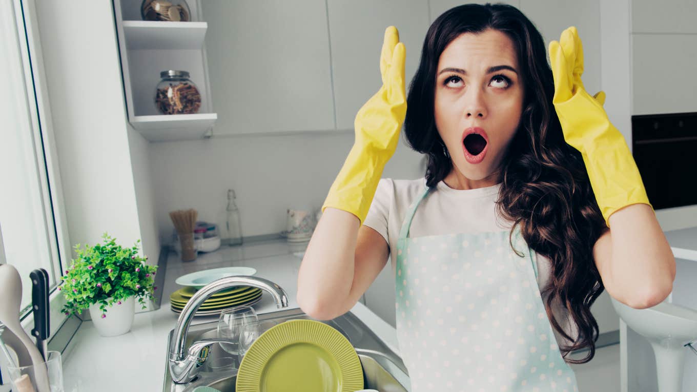 Woman furious and frusterated while doing dishes.