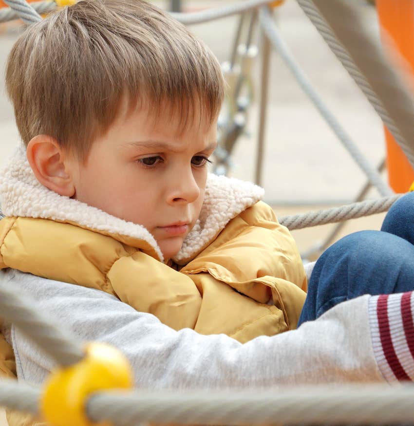 Angry boy self isolates on playground