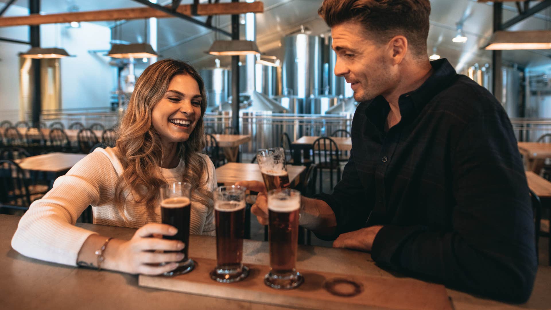 a man and a woman flirting at the bar with drinks