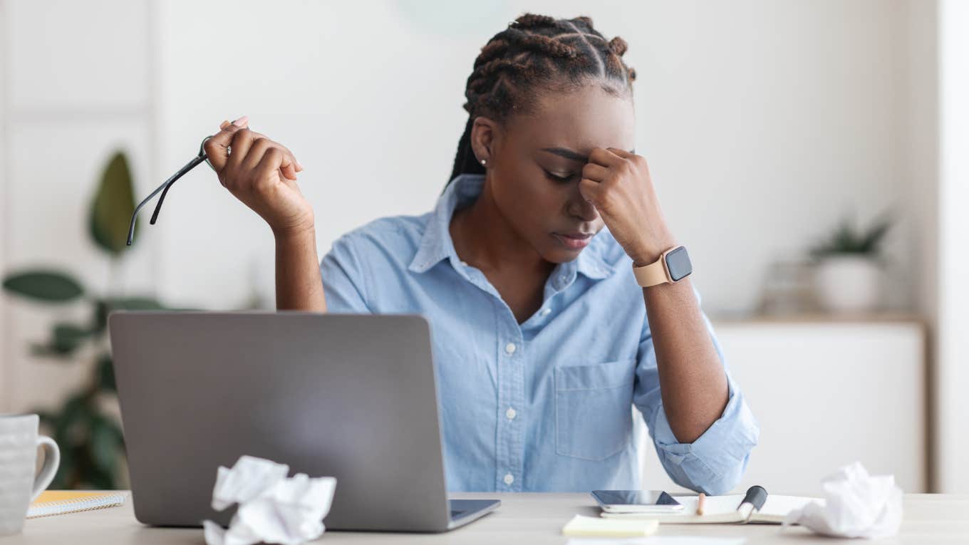 Overworked Female Entrepreneur Massaging Nosebridge At Workplace In Office