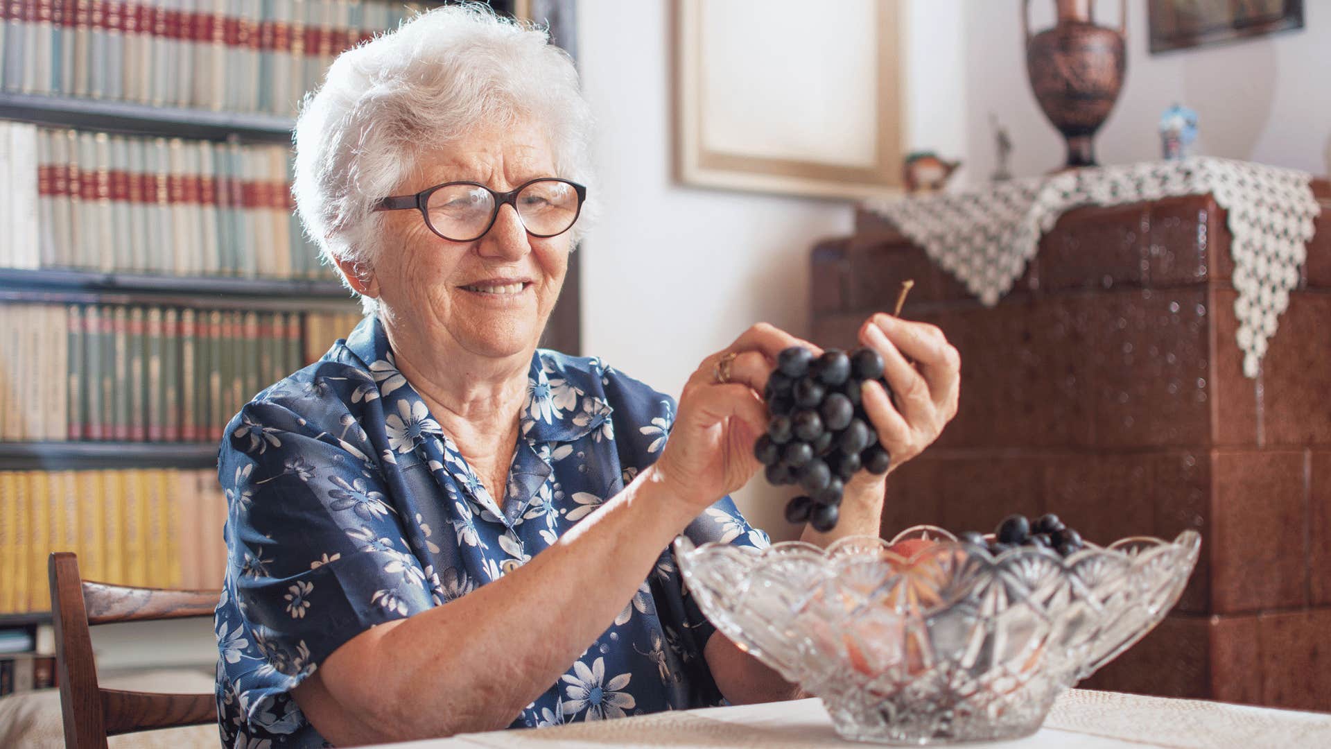 older woman eating grapes